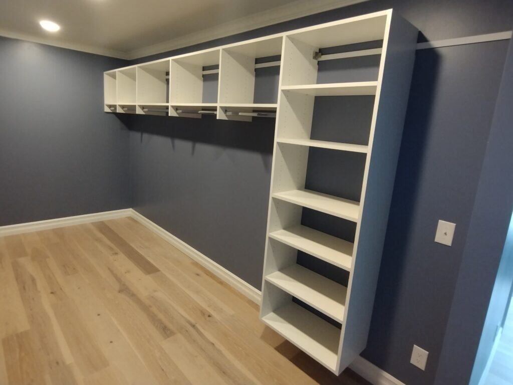 Custom closet shelving and storage units in a modern bedroom.
