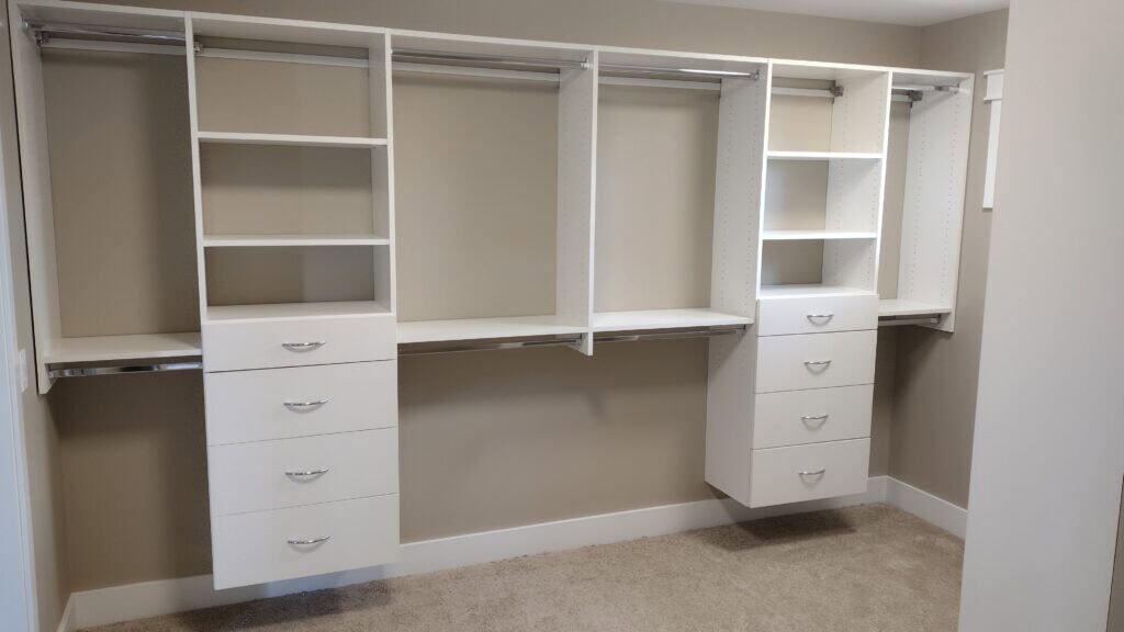 Efficient closet storage with white shelving and drawers for a tidy, organized space.