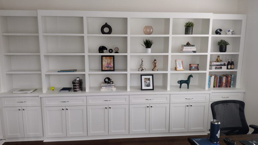 White built-in shelving with decorative items and books.
