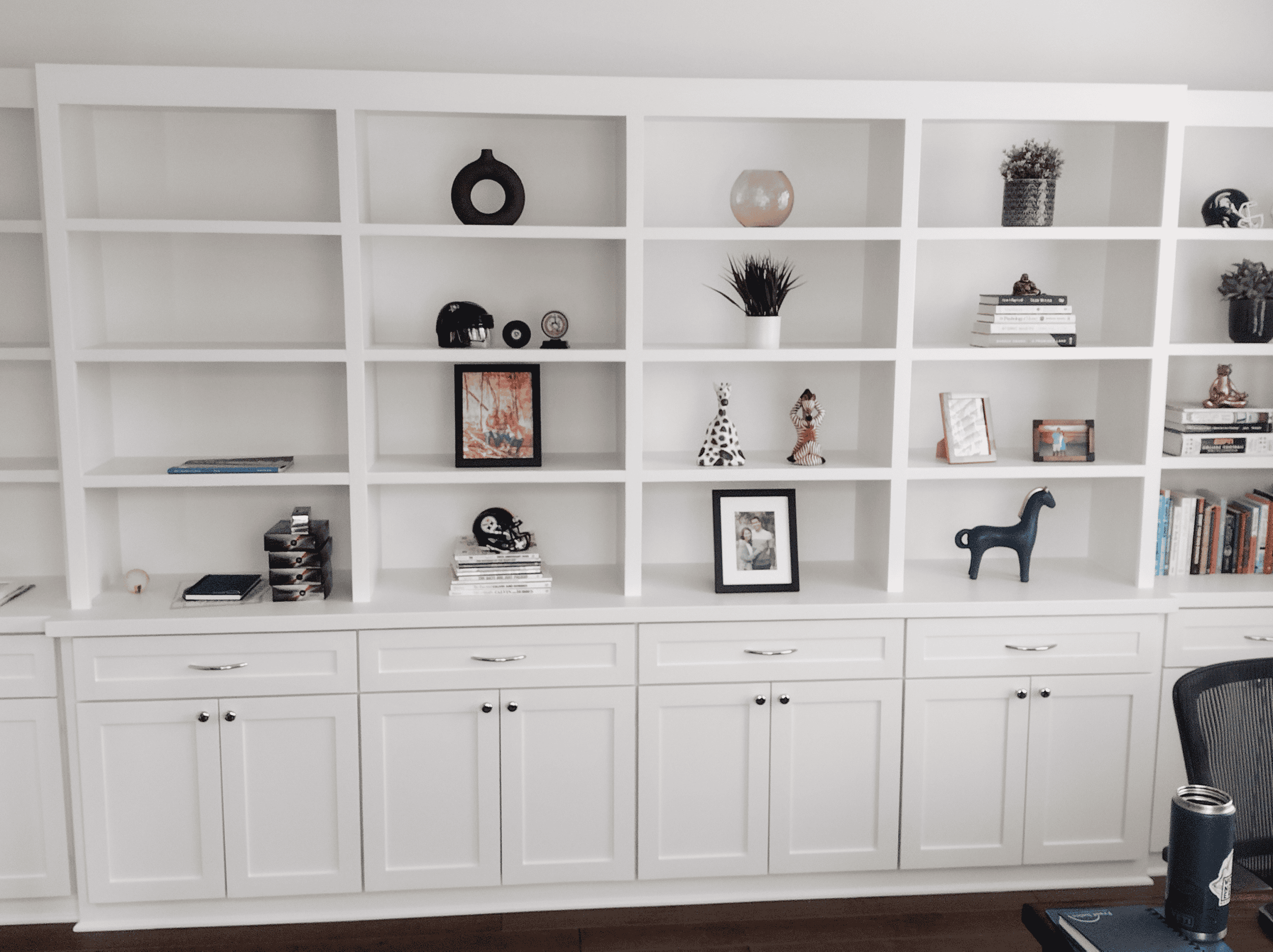 Built-in white bookshelf with decorative accents and books for stylish home organization.