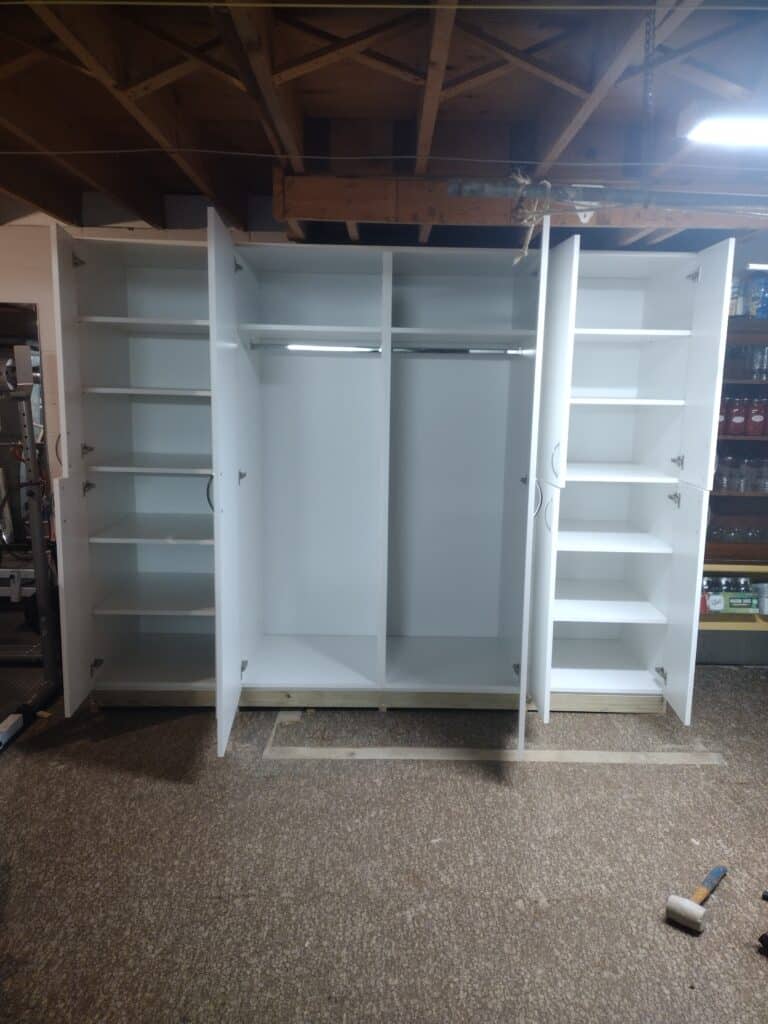 White wardrobe closet with multiple shelves and hanging space for organized clothing storage.