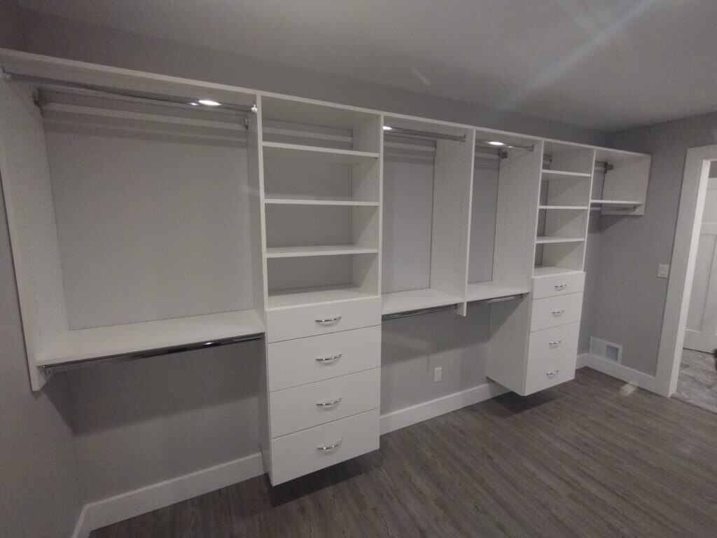 Modern white closet organization system with shelves and drawers for efficient storage.