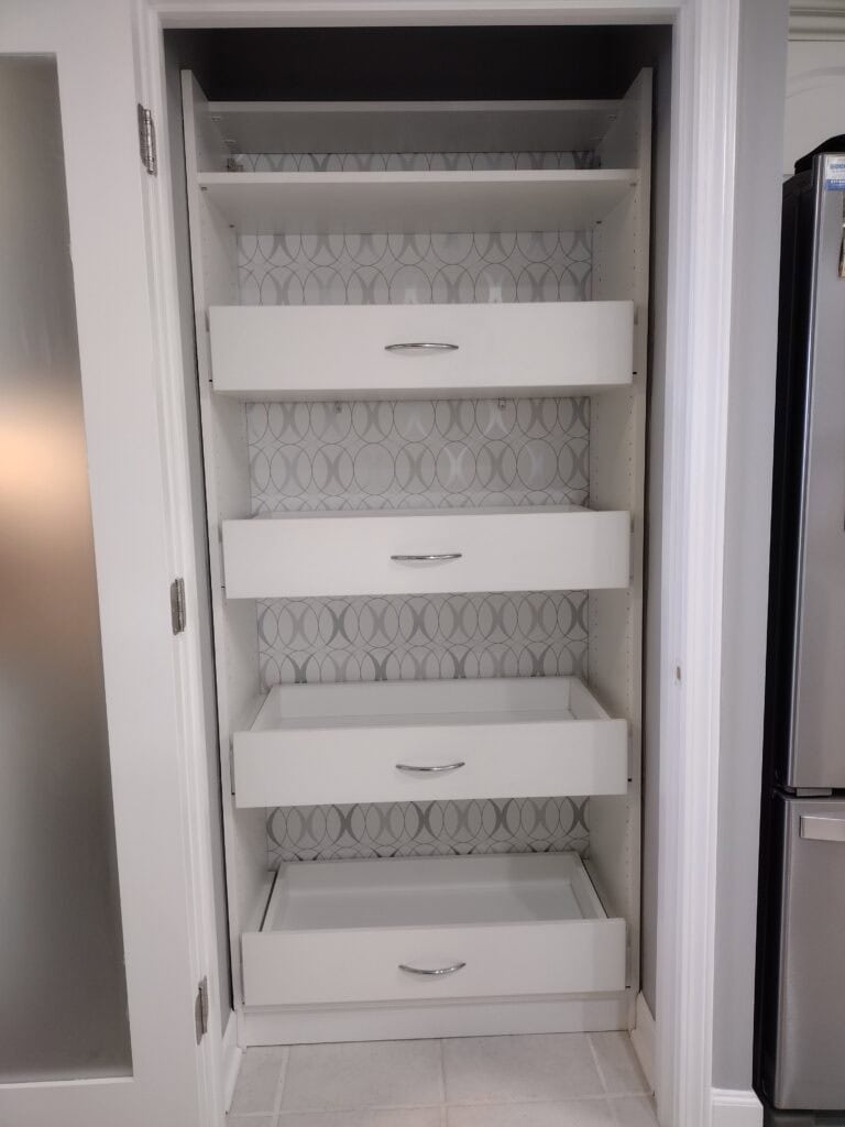 Custom white closet with multiple drawers and shelves for organized storage.