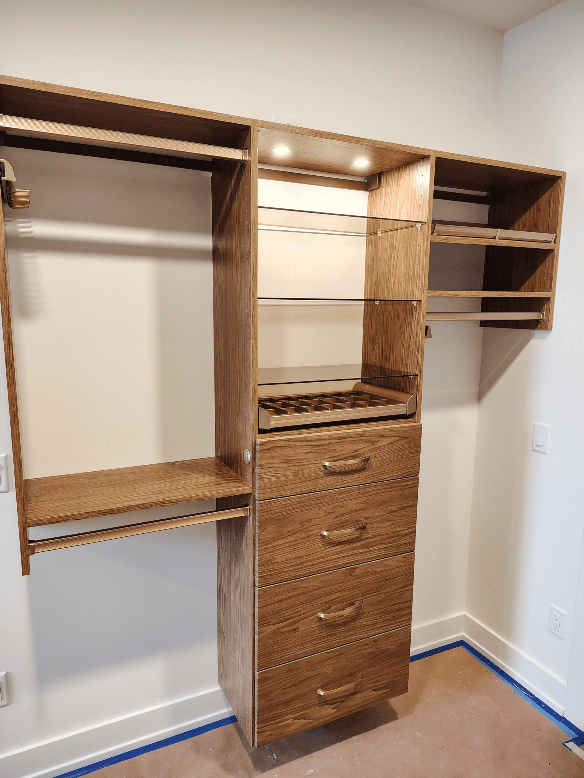 Closet organization system with multiple shelves, drawers, and hanging space for efficient storage.