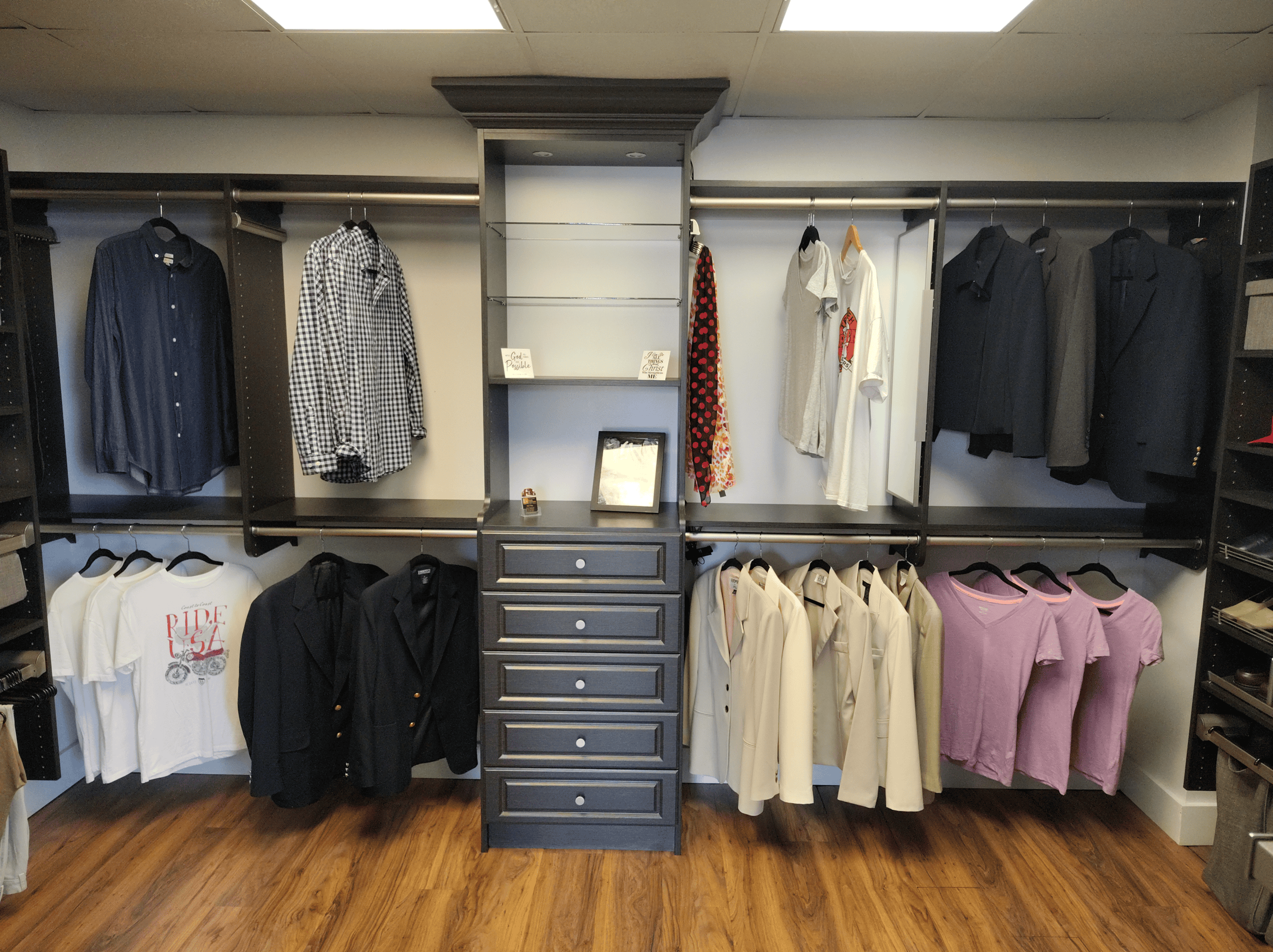 Stylish clothing display wall with shirts, jackets, and sweaters in a retail store setting.